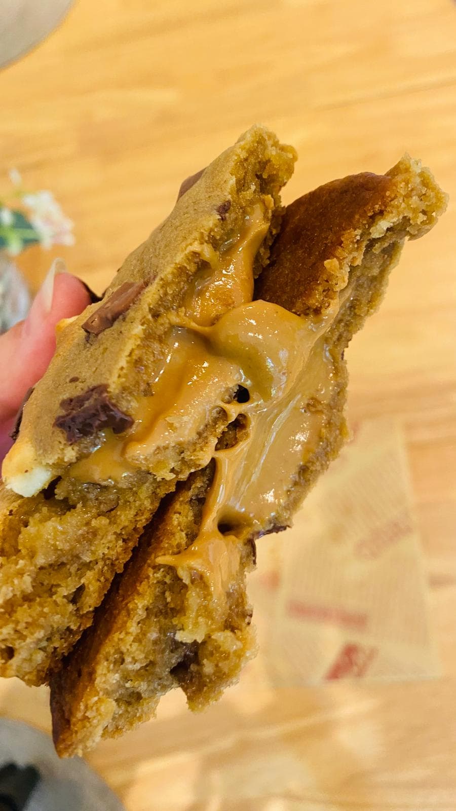 Peanut butter cookie torn open with molten peanut butter centre stretching