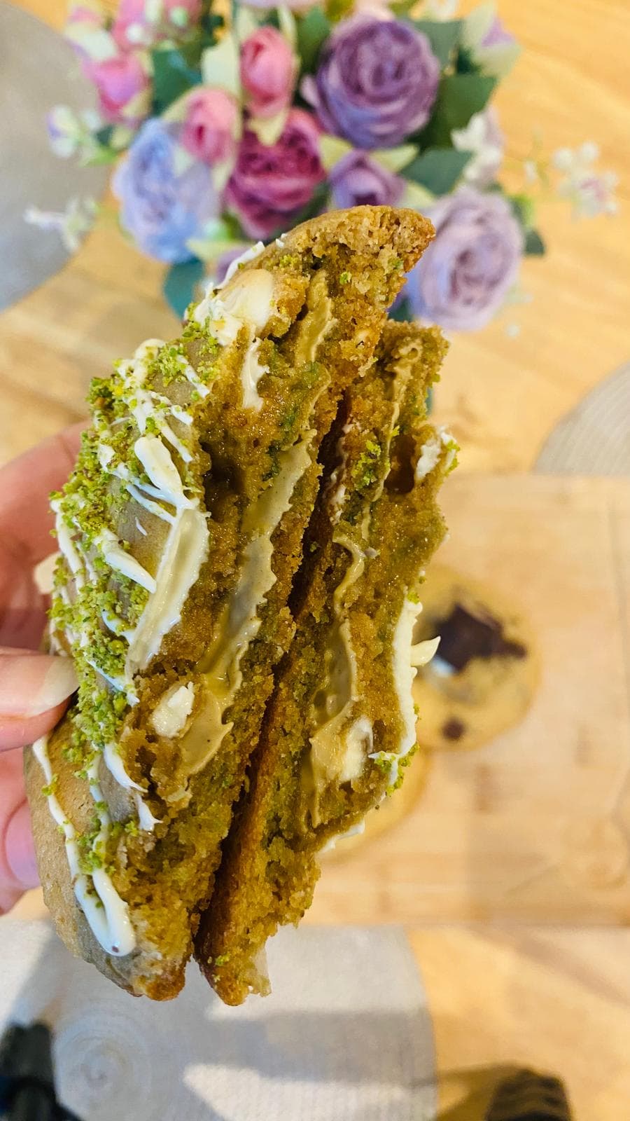 Pistachio white chocolate cookie broken open with green crème